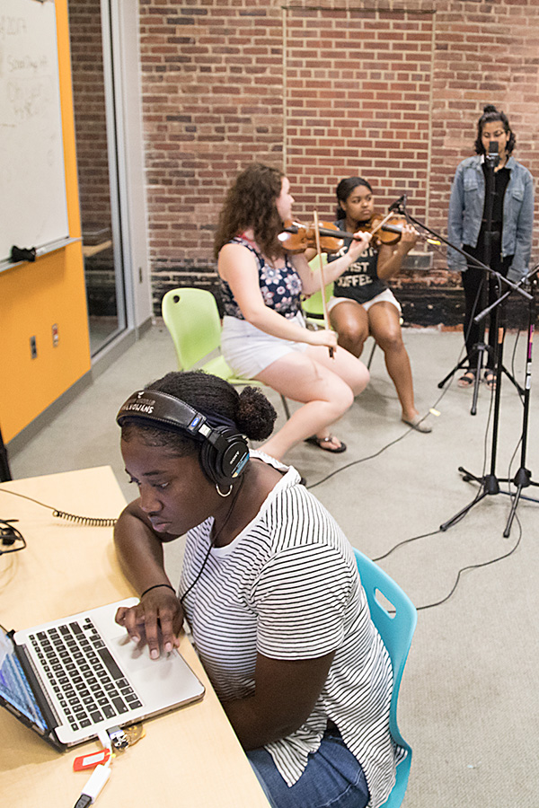 Photograph of a Baltimore School for the Arts recording other students playing violins and singing